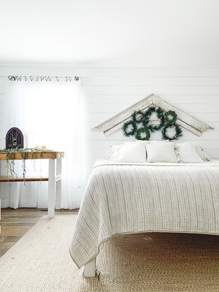 Cozy Cottage Style Farmhouse Bedroom Decorated For Christmas With Layered Wreaths & Twinkle Lights